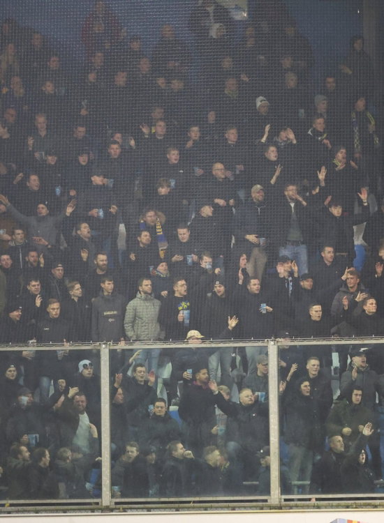 Supporters in de mist op de tribune