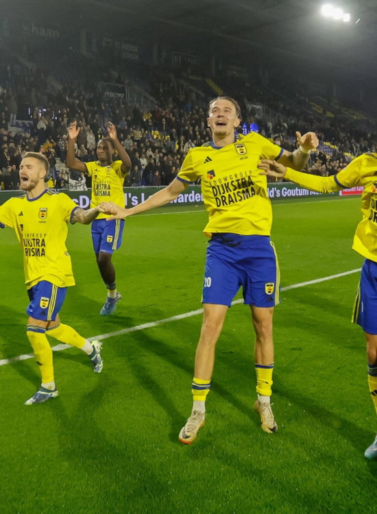 Spelers vieren een doelpunt op het veld