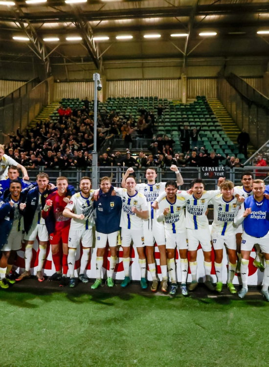 Groepsfoto team met supporters in het stadion