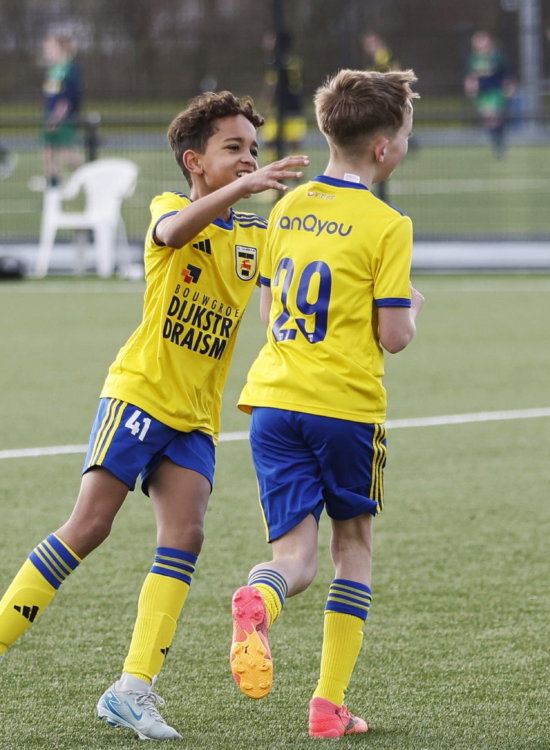 Twee jeugdspelers in geel op het veld