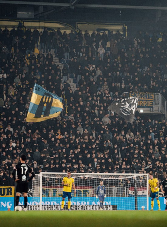 Tribune met vlag tijdens avondwedstrijd