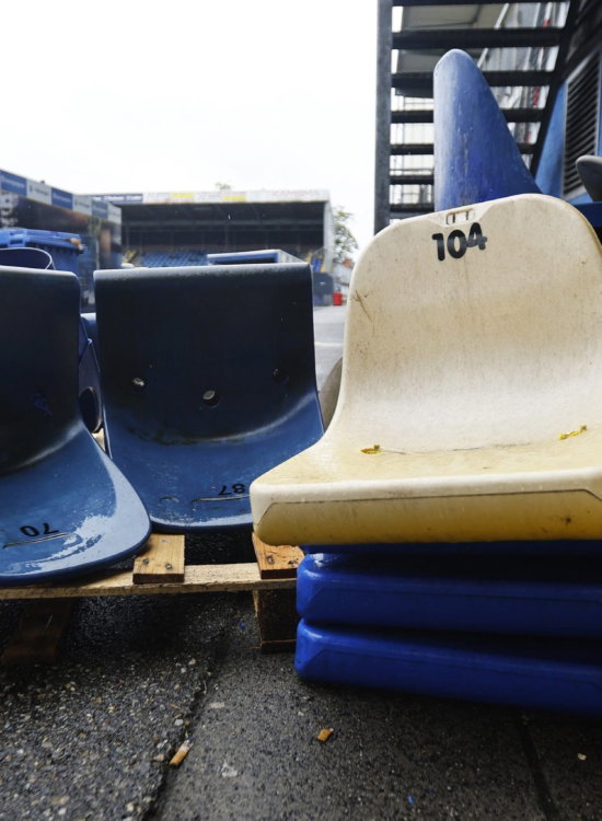 Oude stadionstoelen op een pallet