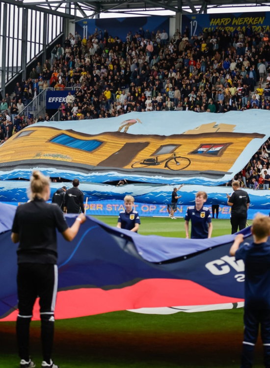 Groot spandoek op het veld voor de wedstrijd