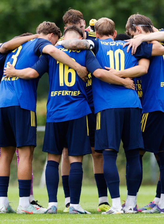 Jeugdteam in blauw vormt een kring