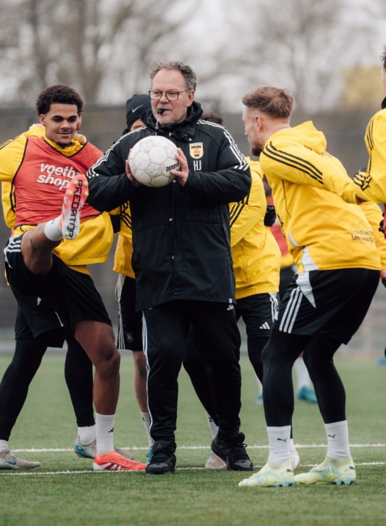 Jeugdtraining met trainer en ballen