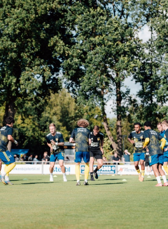 Jeugdtraining op veld met bomen