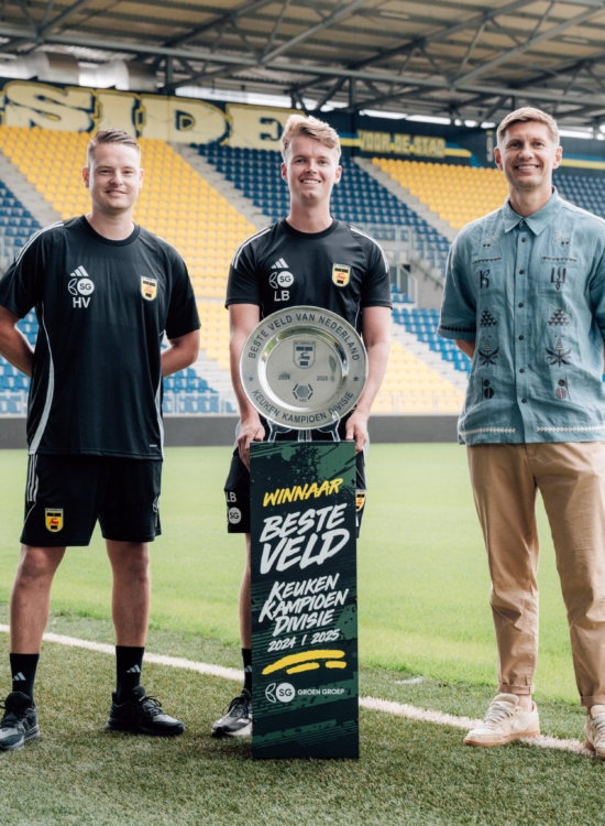 Spelers en partner met de schaal op het veld