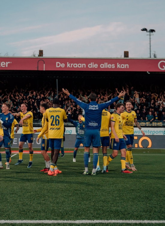 Spelers op het veld voor de tribune