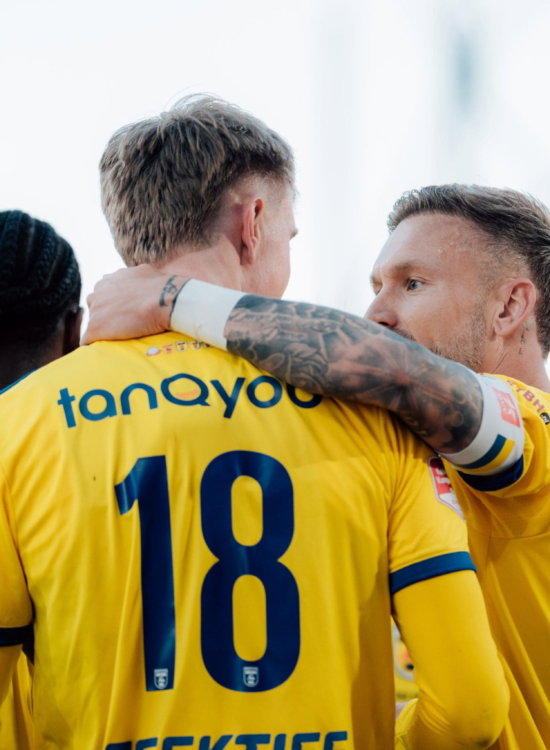 Speler met nummer 18 omhelst een teamgenoot
