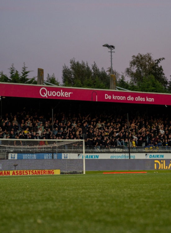 Scorebord en tribune bij schemer