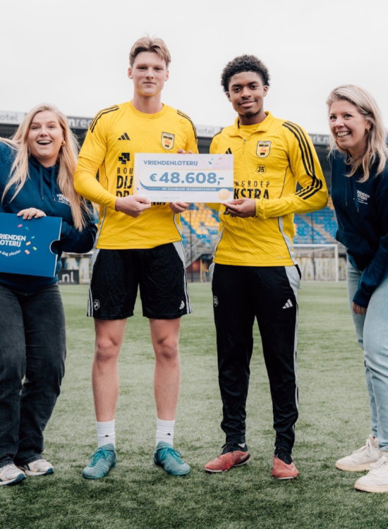 Cheque-uitreiking op het veld met spelers