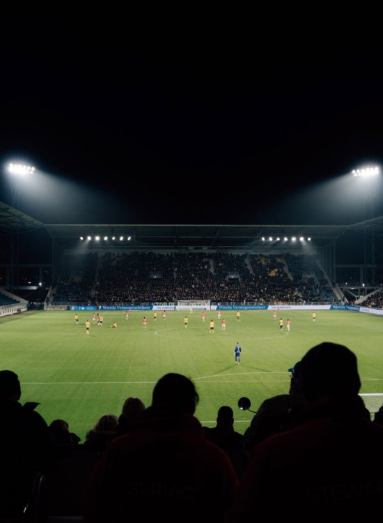 Silhouetten van supporters bij een avondwedstrijd