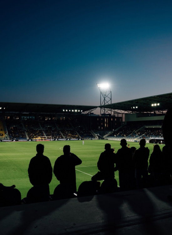 Supporters in silhouet bij avondwedstrijd