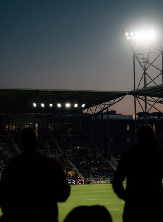 Silhouetten van supporters bij avondlicht