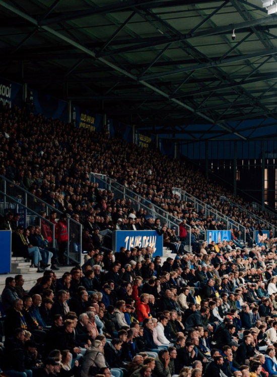 Volle tribune bij een avondwedstrijd