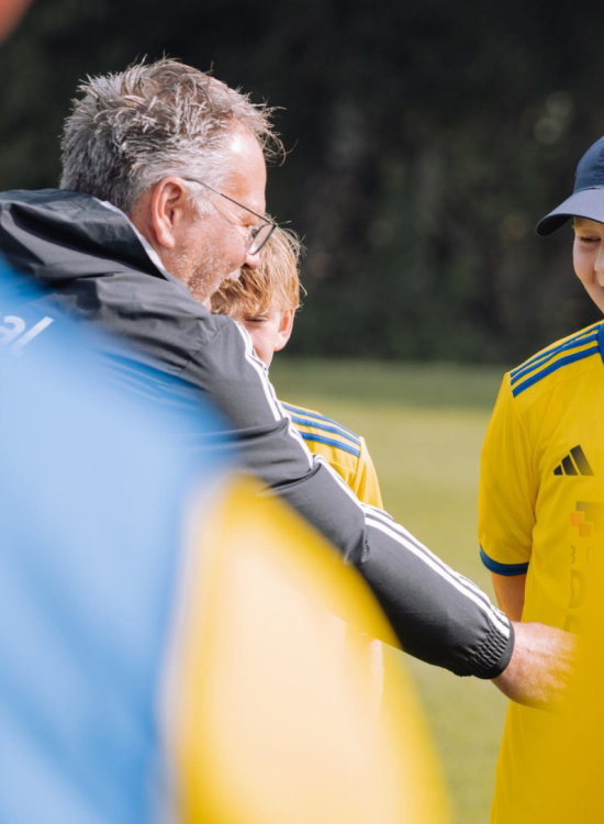 Begeleider en kind in Cambuur-shirt