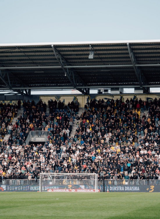 Overzicht van een volle tribune bij daglicht
