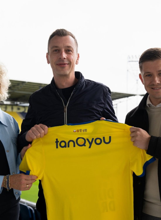 Partners met tanQyou-shirt op het veld
