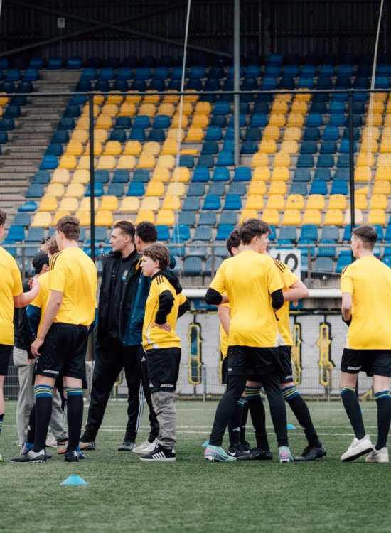 Jeugdselectie op het veld voor de tribune