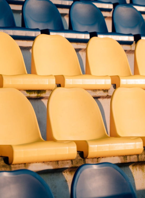 Gele en blauwe stoelen op de tribune