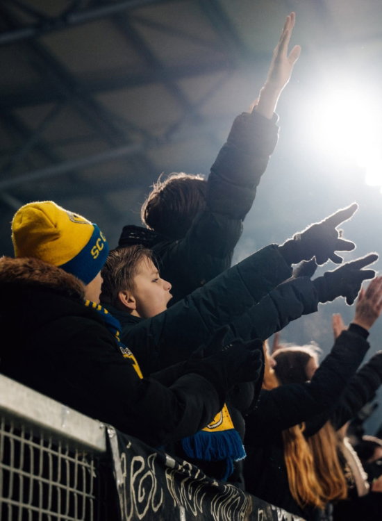 Supporters juichen onder het stadionlicht