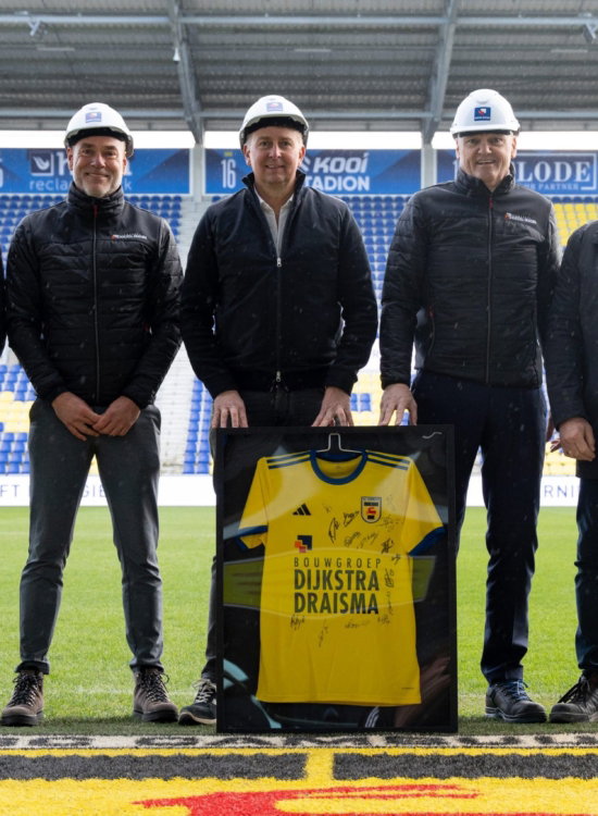 Partners met bouwhelm en shirt op het veld
