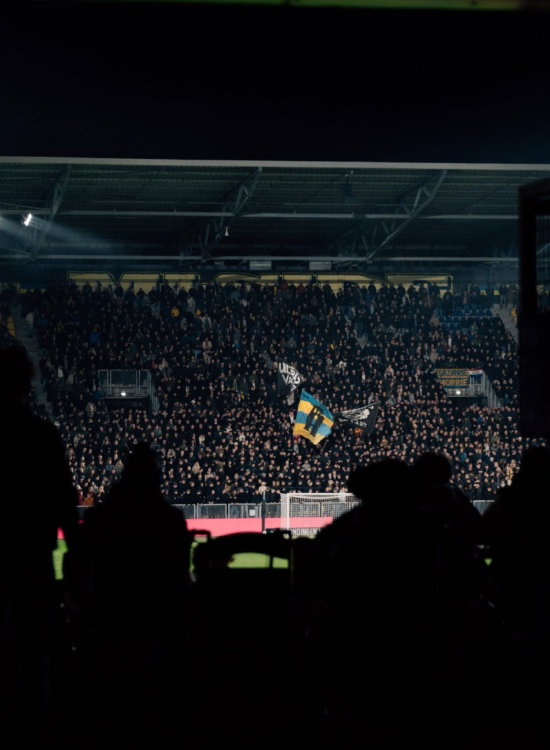 Donkere tribune bij een avondwedstrijd