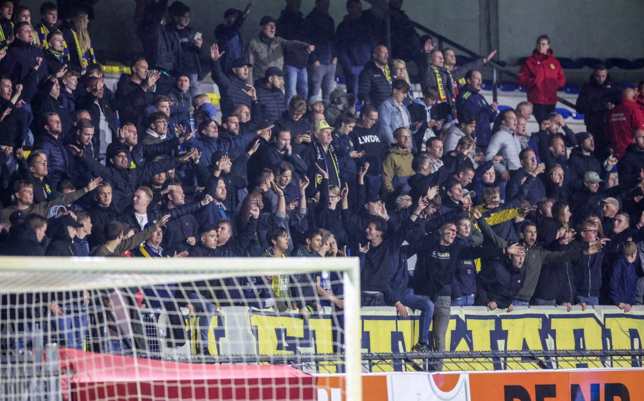 Supporters achter het doel bij een avondwedstrijd