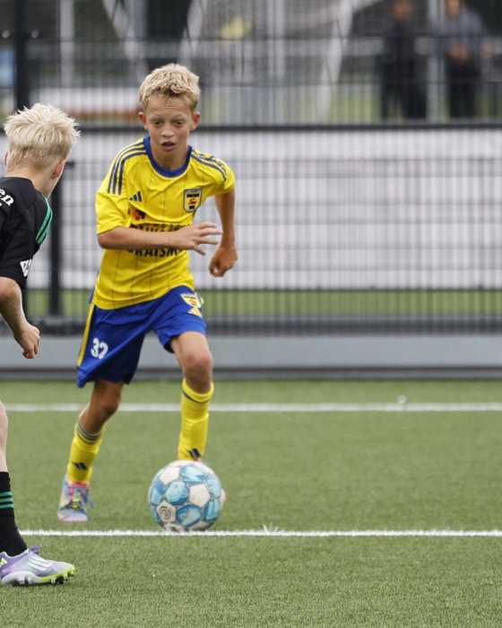 Jeugdspelers in duel bij het doel