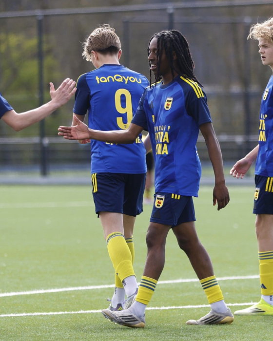 Jeugdspelers in blauw geven high fives