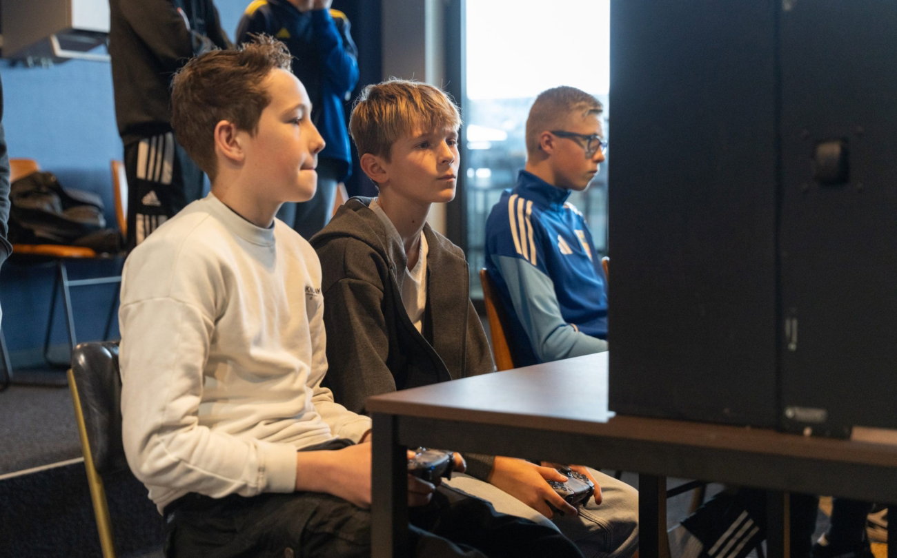 Kinderen kijken naar een scherm in het stadion