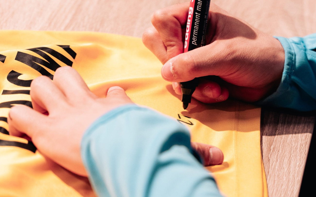Hand signeert een geel Cambuur-shirt