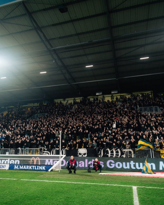 Volle tribune bij een avondwedstrijd