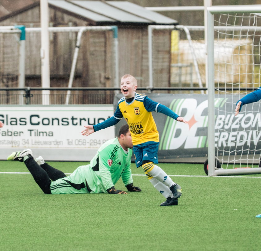 Jeugdspeler scoort langs de liggende keeper