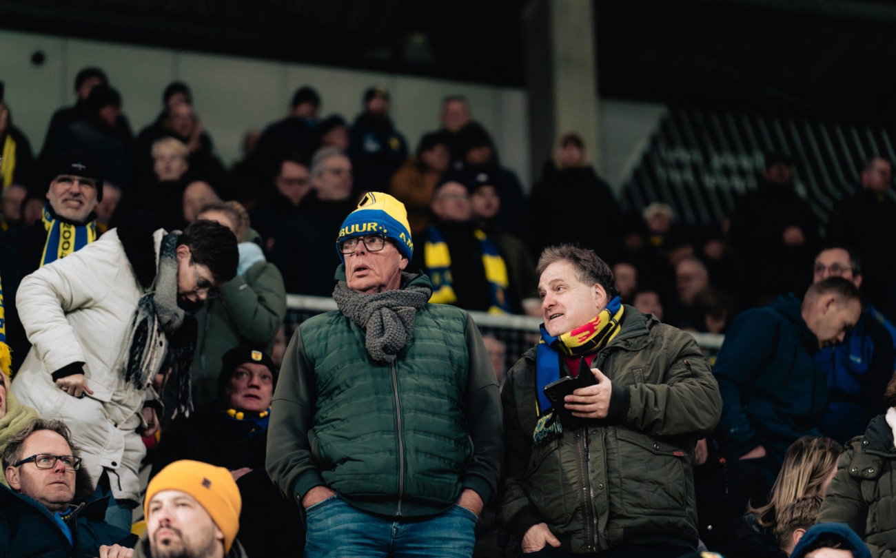 Supporters met sjaals volgen de wedstrijd
