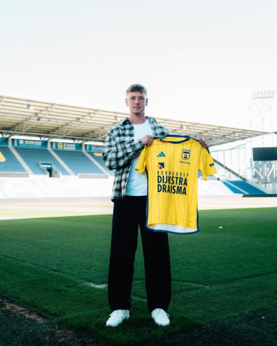 Partner met geel shirt op het veld