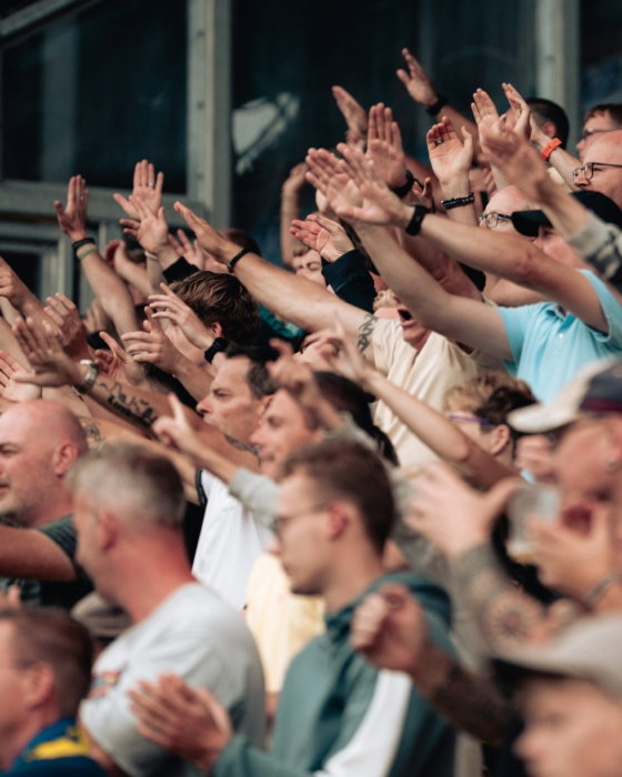 Supporters zingen met opgestoken armen