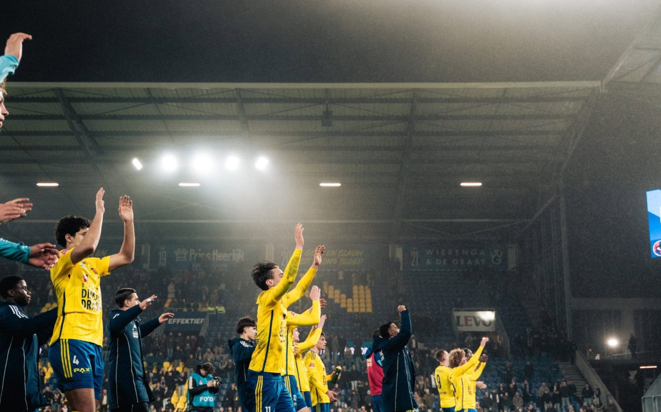 Spelers vieren onder het stadionlicht