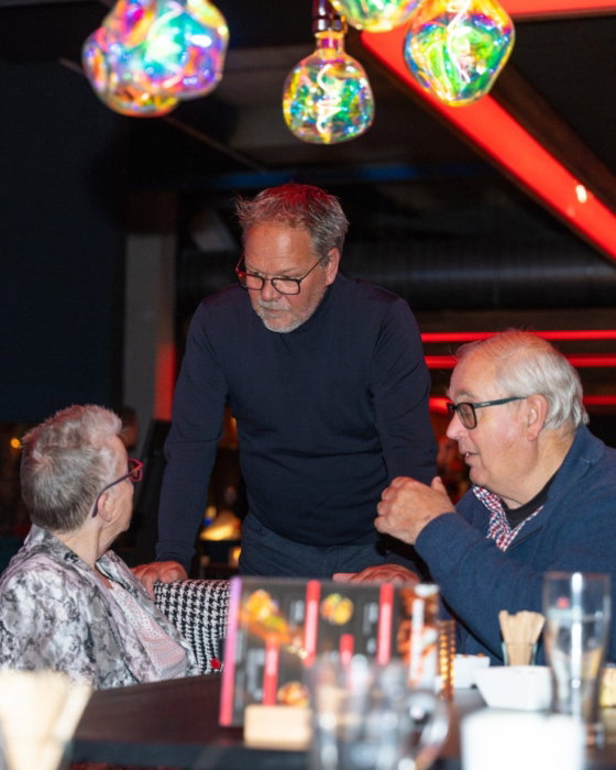 Gasten aan tafel bij een avond in de lounge