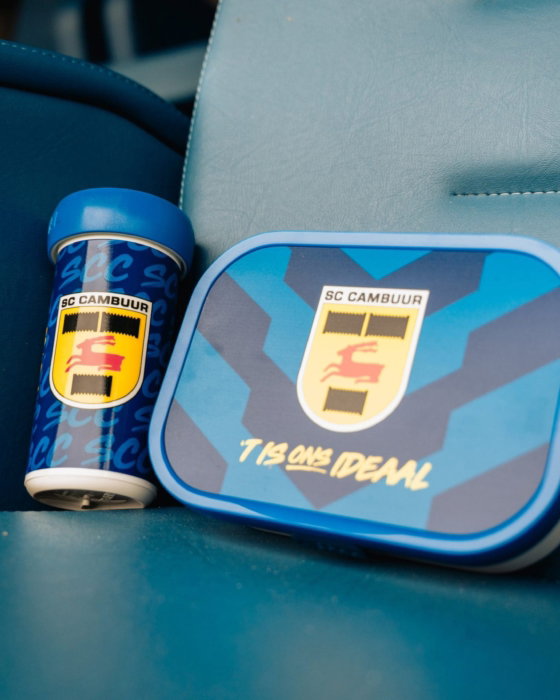 Cambuur-drinkbeker en broodtrommel op een stadionstoel