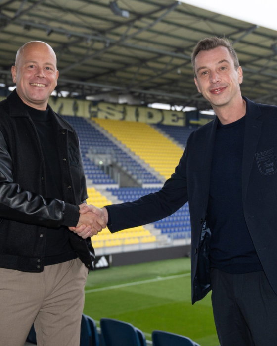Partners schudden elkaar de hand op het veld