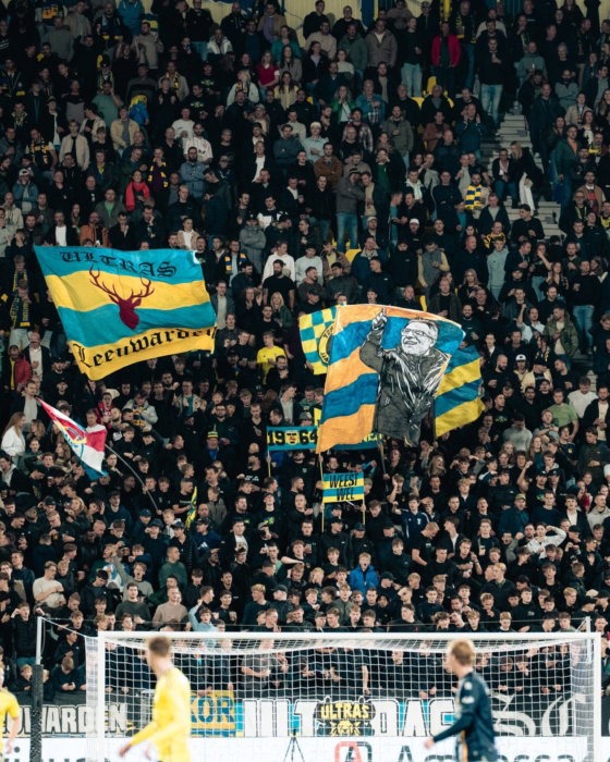 Tribune met vlaggen achter het doel