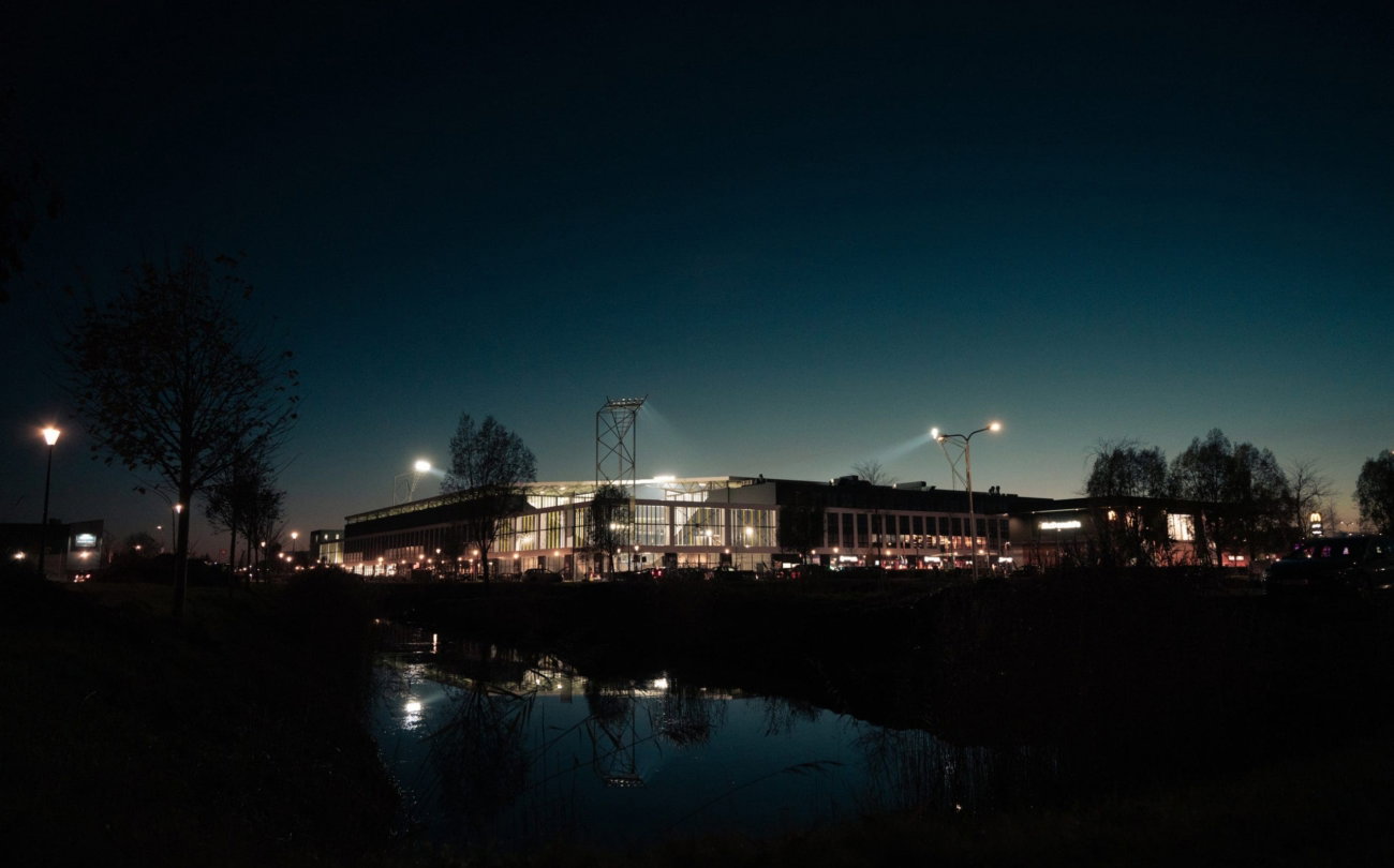 Kooi Stadion verlicht aan het water bij nacht