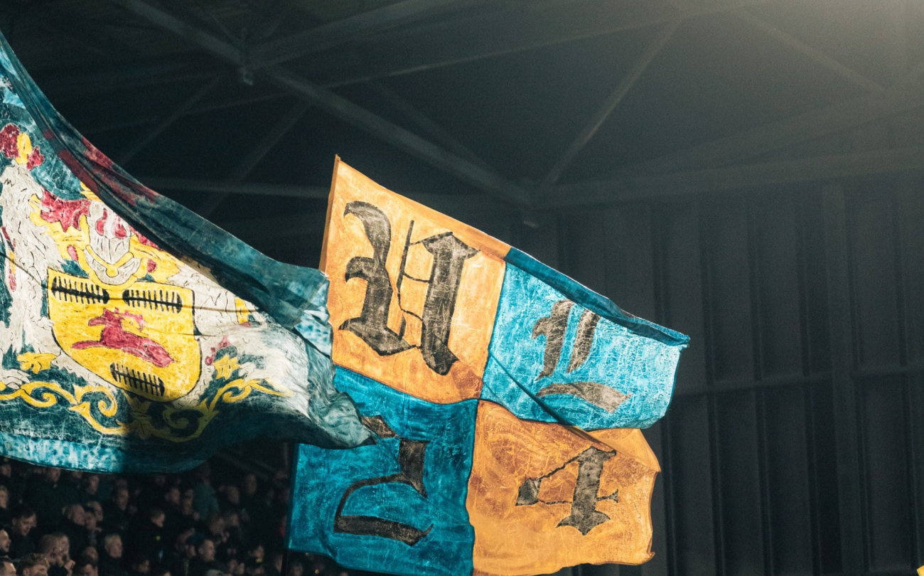 Twee vlaggen boven de supporters