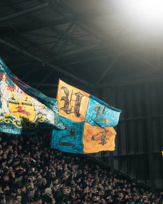 Twee vlaggen boven de supporters