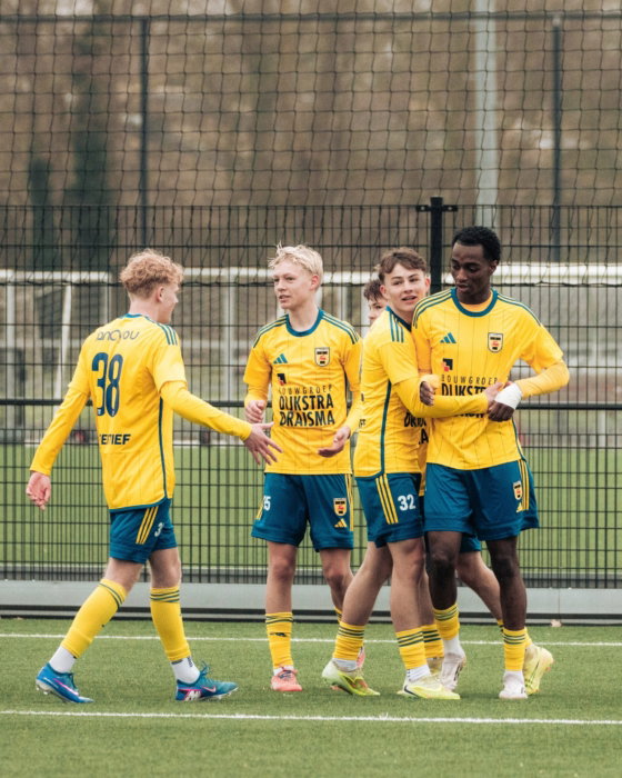 Jeugdspelers in geel lopen samen