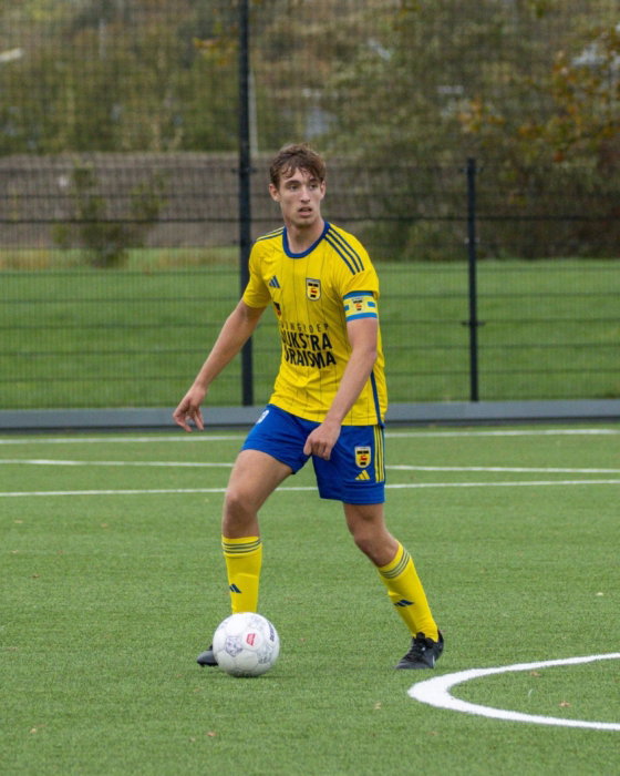 Jeugdspeler in geel op het veld