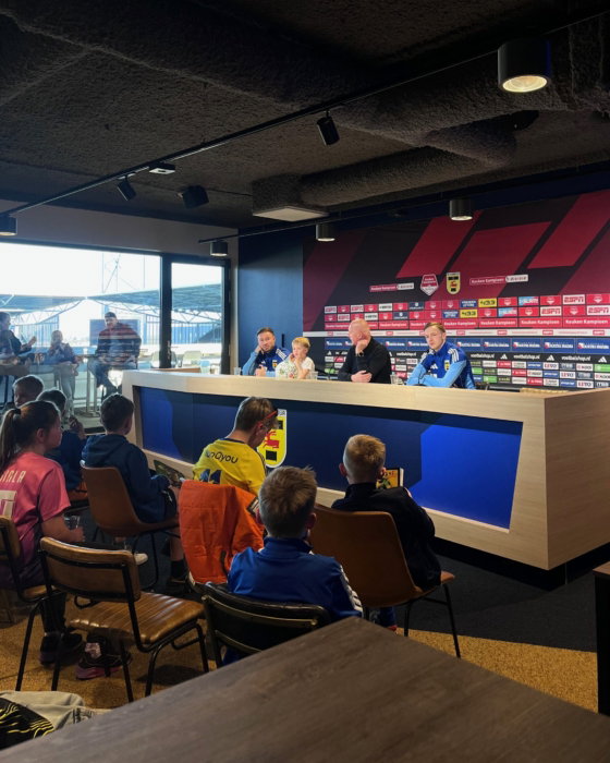 Gasten in de businessclub met zicht op het veld