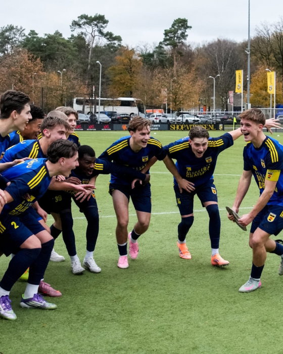 Jeugdspelers vieren met elkaar op het veld