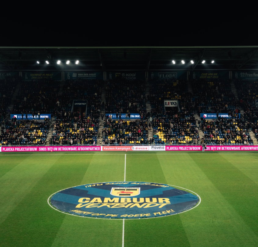 Middenveld met clublogo onder het licht